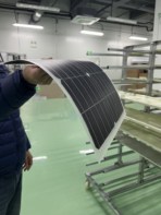 A photo showing the new bendy silicon solar cells flopping over in a person's hand like a piece of flimsy card