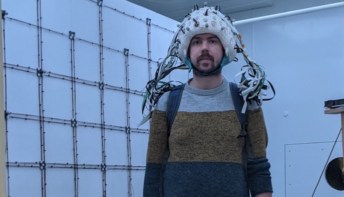 Researcher Niall Holmes wears the brain imaging helmet
