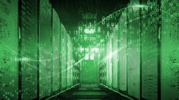Supercomputer bathed in green light surrounded by binary code
